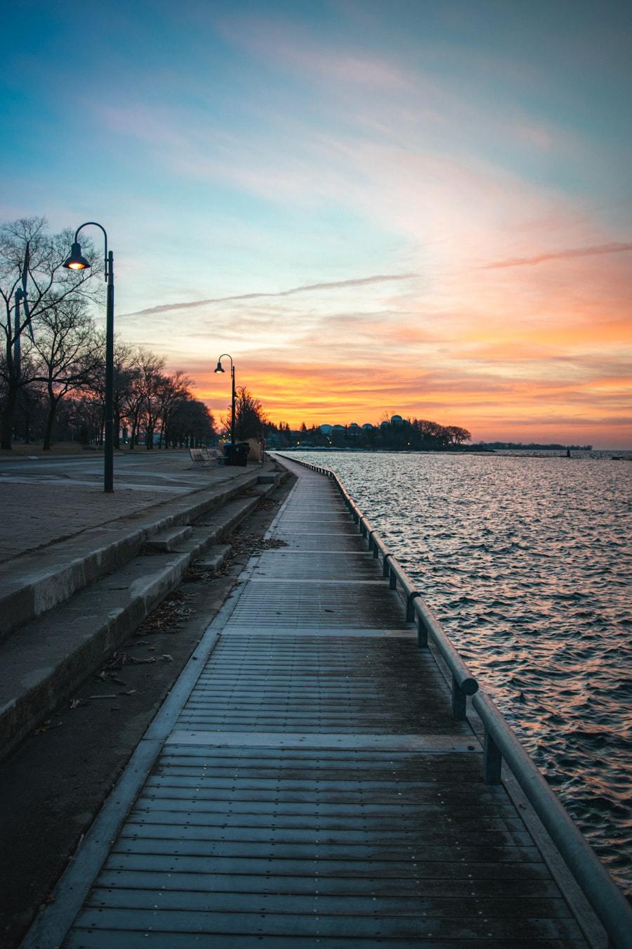 Wooden dock on water at sunset
