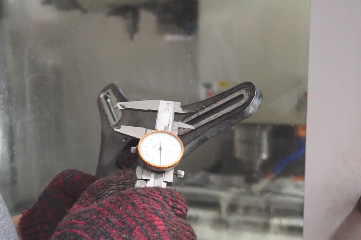 Final QC inspector using digital caliper to measure bearing puller jaw tolerance - ensures batch consistency