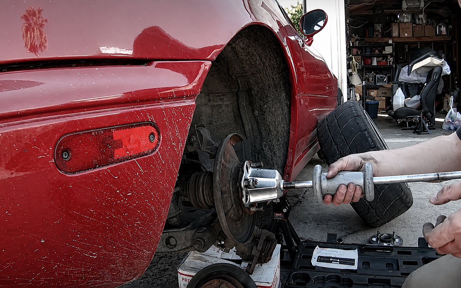 Wheel bearing removal using a bearing puller tool in a professional automotive repair environment