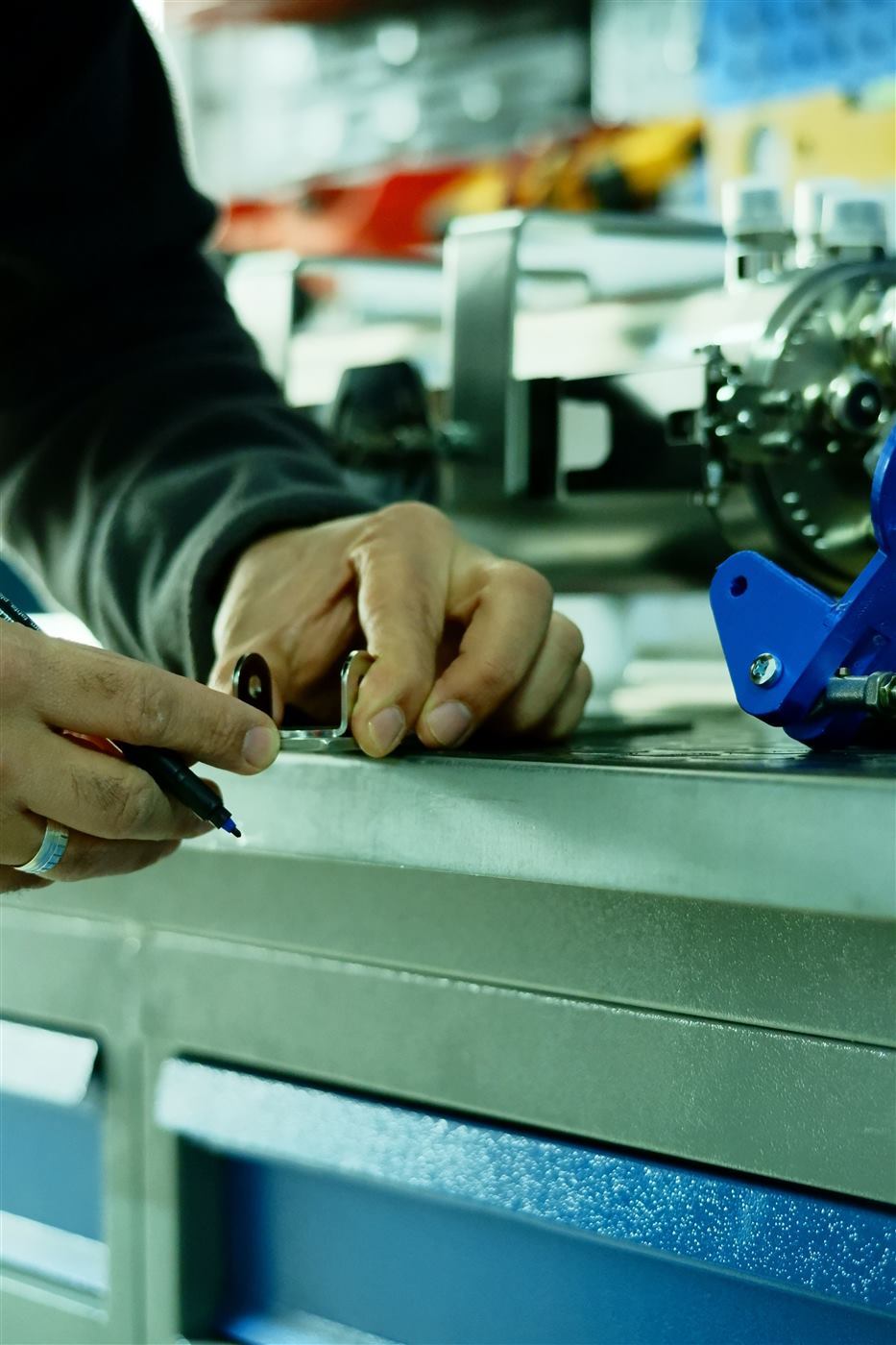Hands working on precision machinery in a workshop