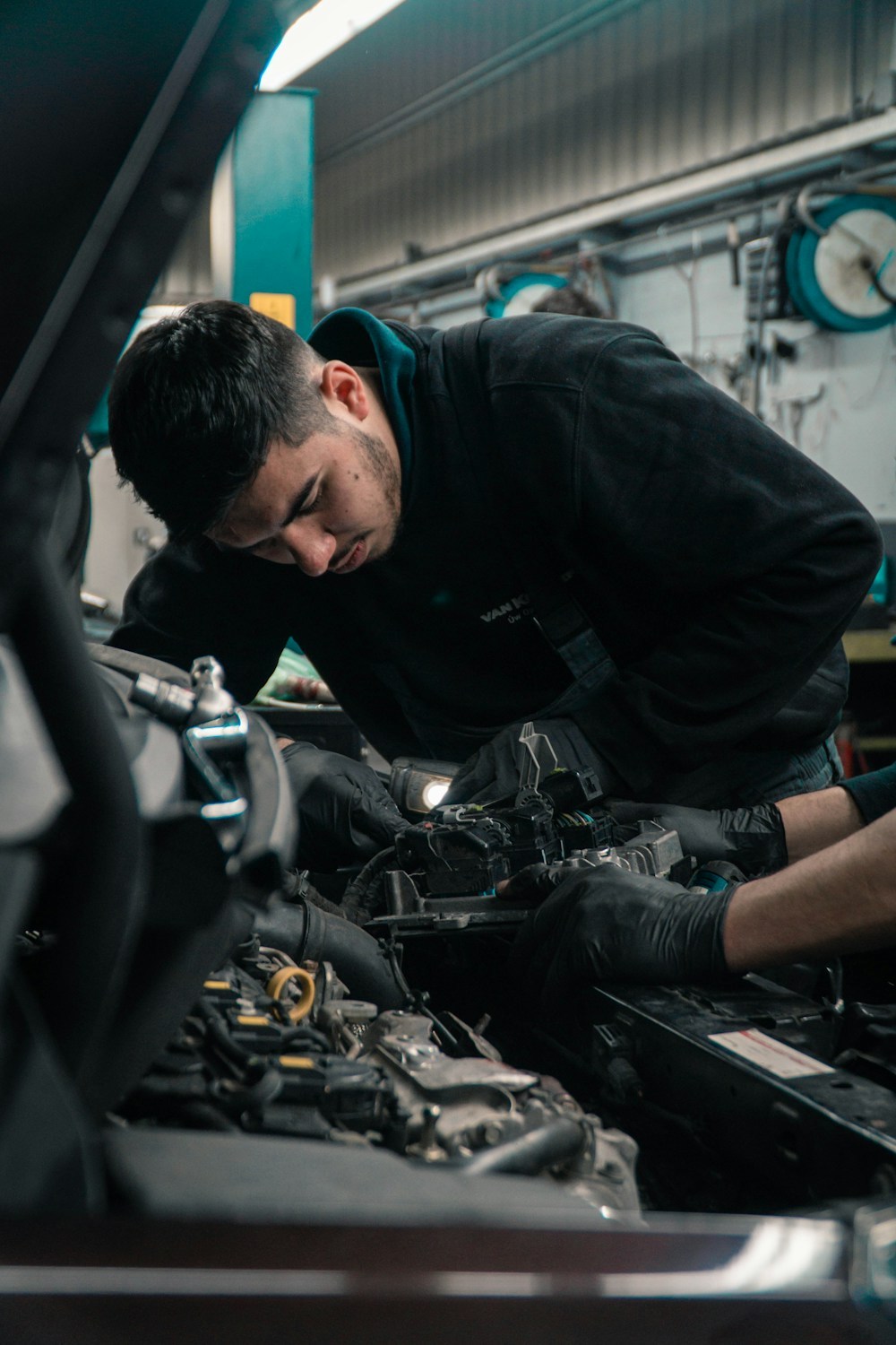 Technician handling drivetrain parts in a workshop