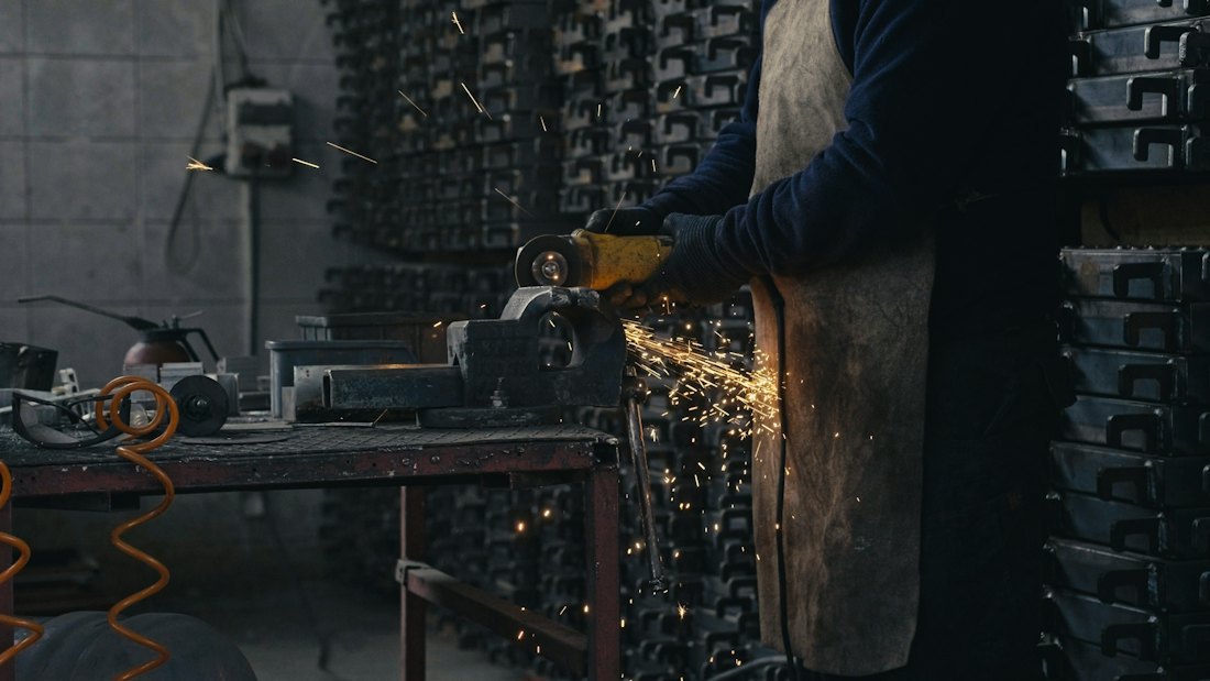 Worker performing precision metalwork in a workshop