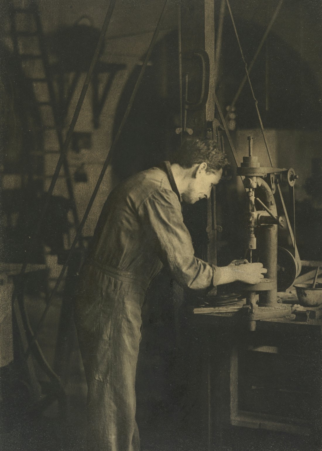 Workshop technician using a drill press