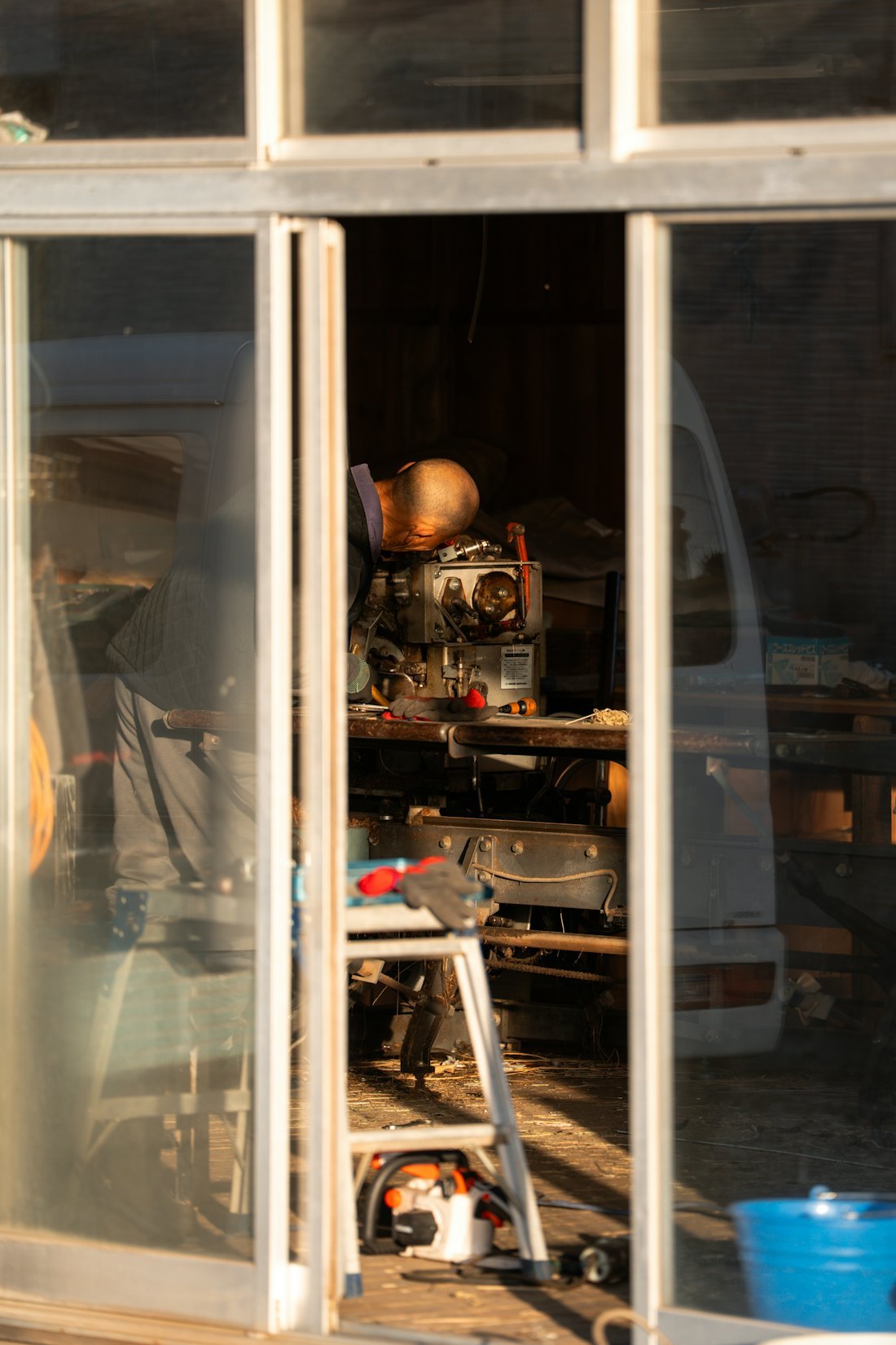 Technician working on compact mechanical equipment in a service workshop