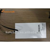 white paper hang tag with a black string