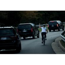 Woman follows Donald Trump around on bicycle sticking her middle finger up