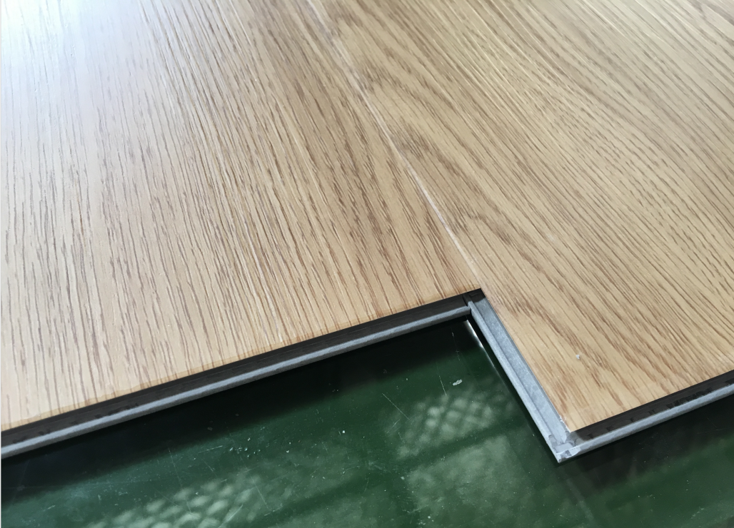 Hands installing click-lock vinyl plank flooring with tapping block