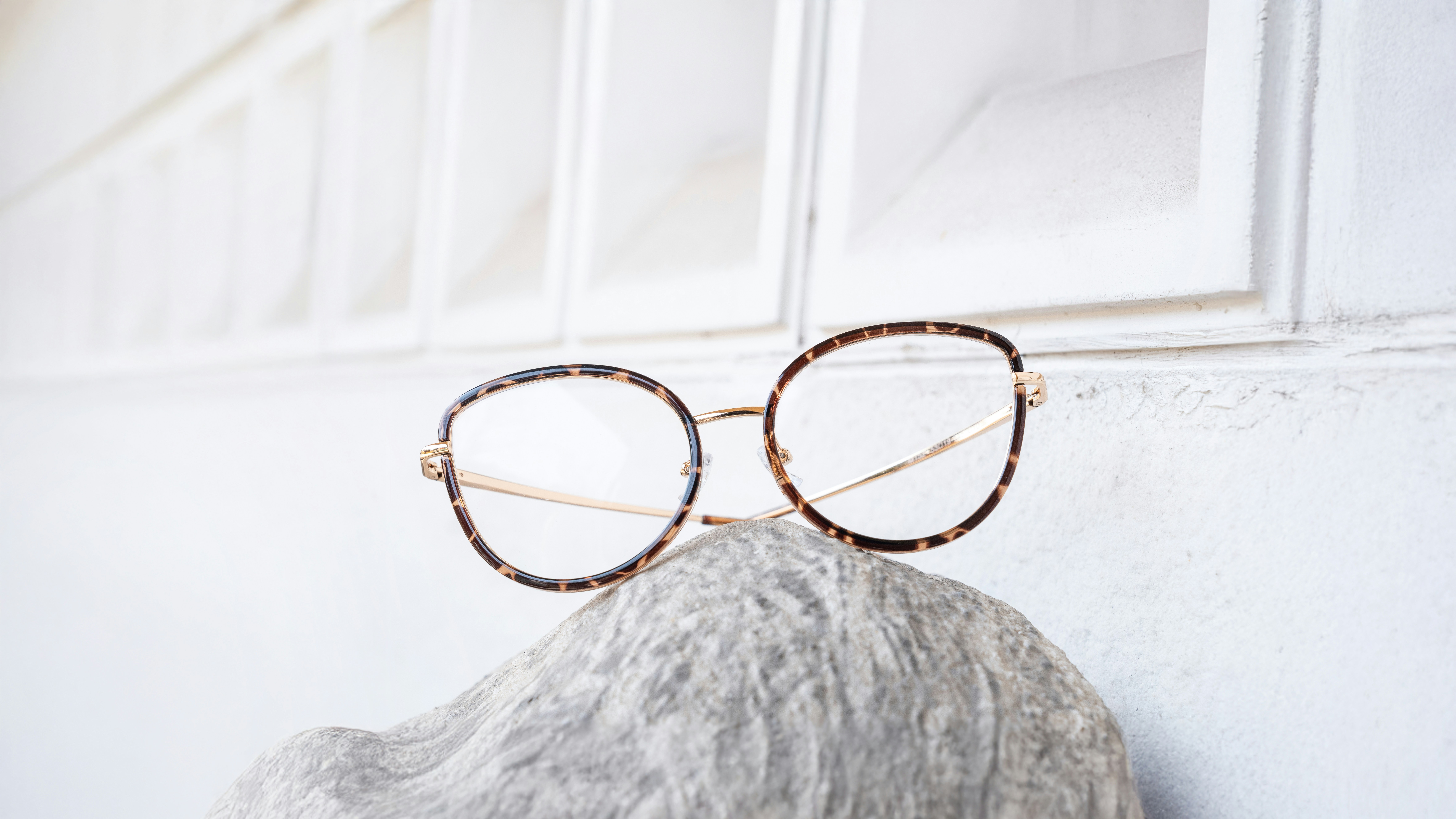 Fashion-forward eyewear styles 2026 A collection of fashion-forward eyeglasses in various geometric shapes and soft neutral colors.