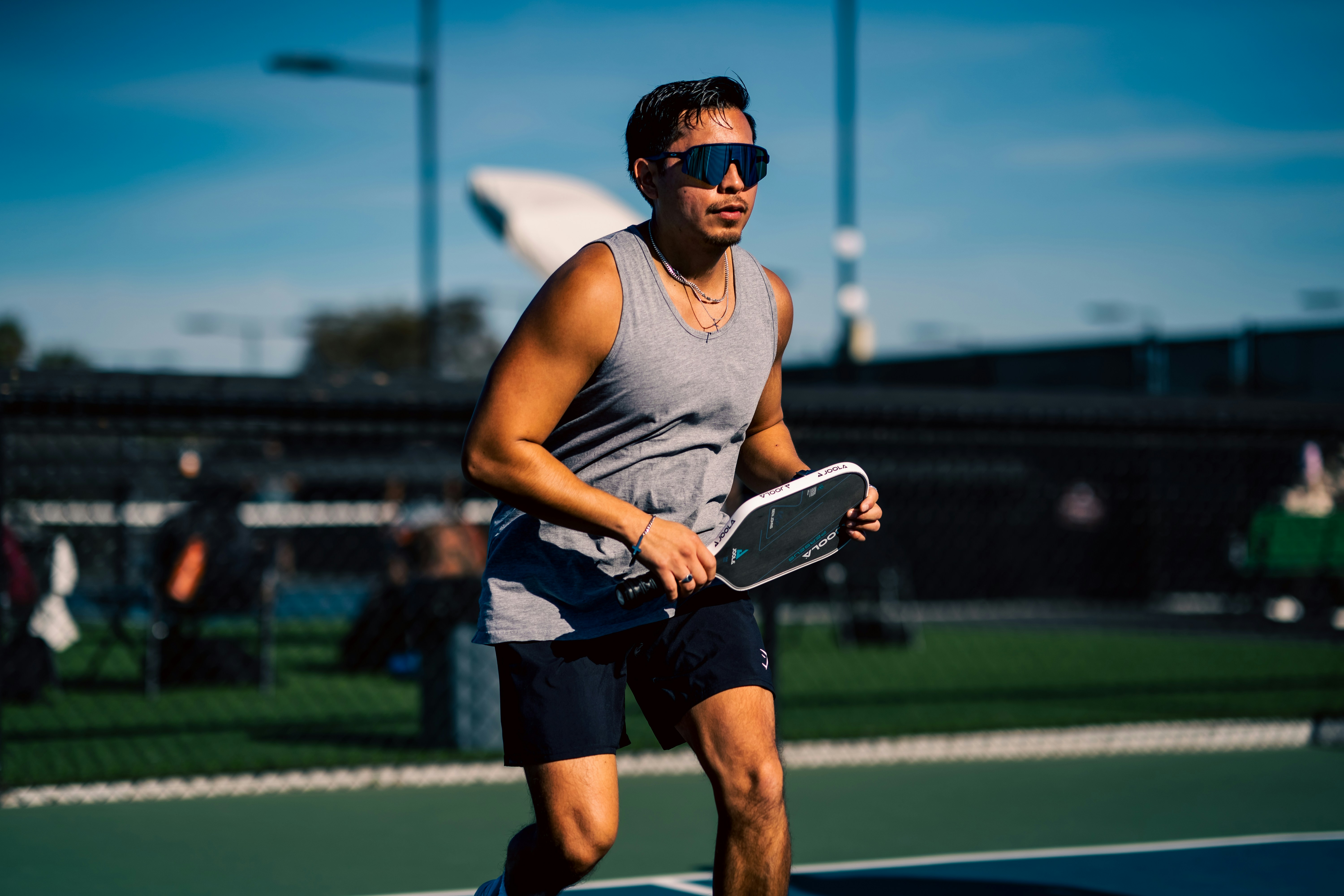 An athlete wearing glasses with flexible spring hinges, showcasing a secure fit during motion.