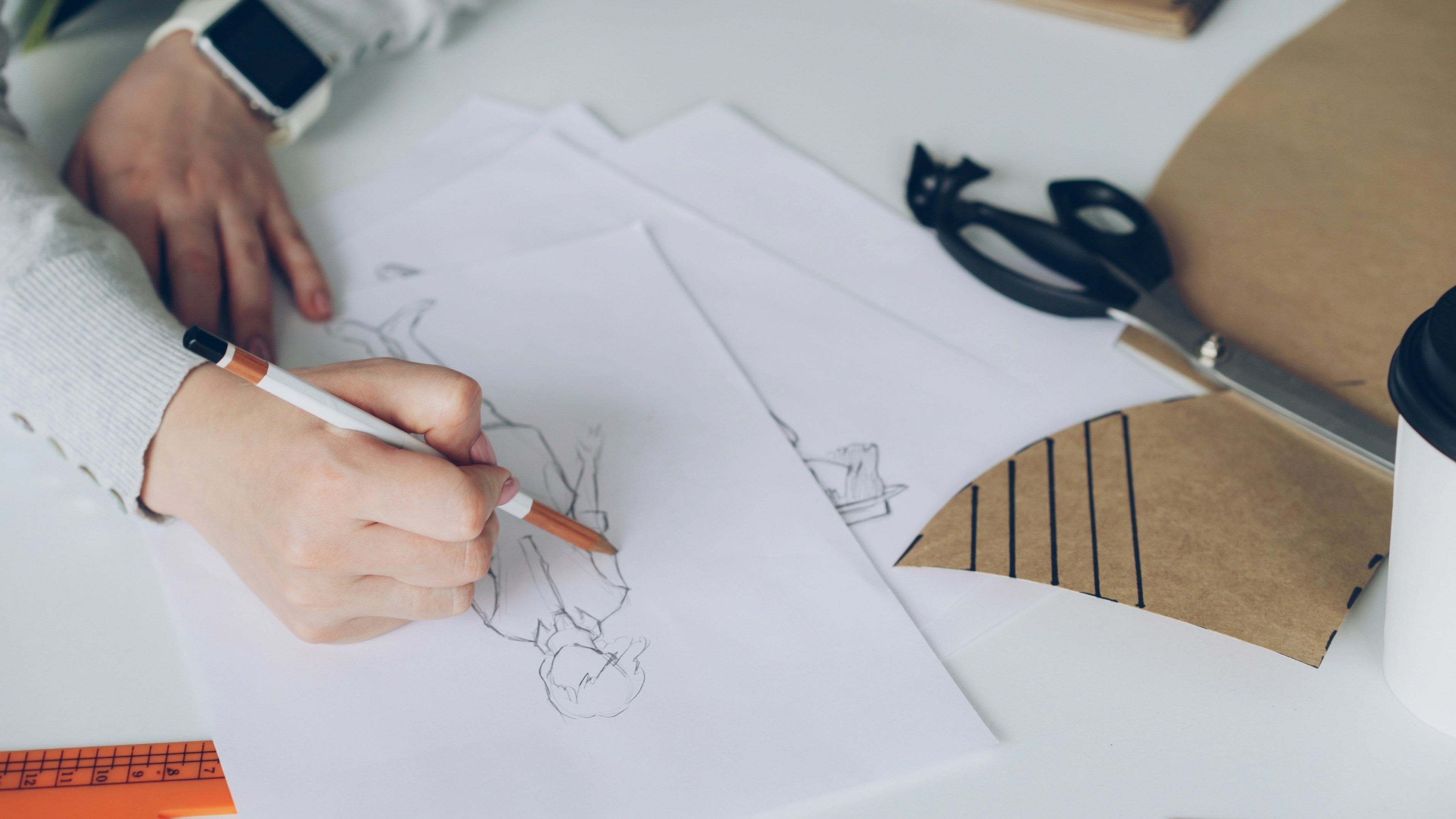 A designer sketching new eyewear designs for cat-eye and aviator frames