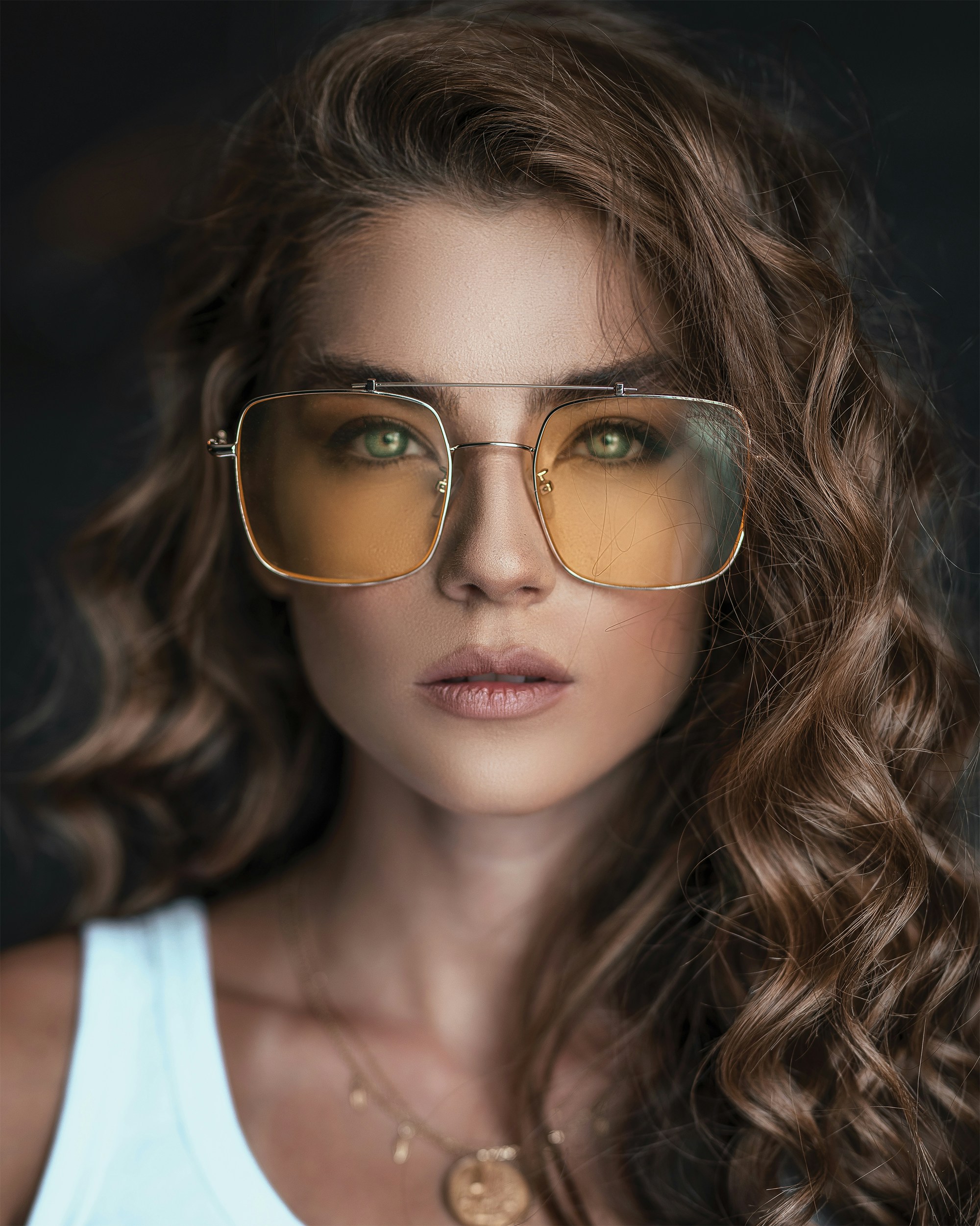 A person wearing stylish square metal frame sunglasses, showcasing a clean and modern look.