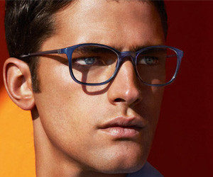 Model wearing acetate optical frames against a warm backdrop