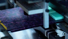 CNC milling machine cutting a dark tortoise acetate sheet in production