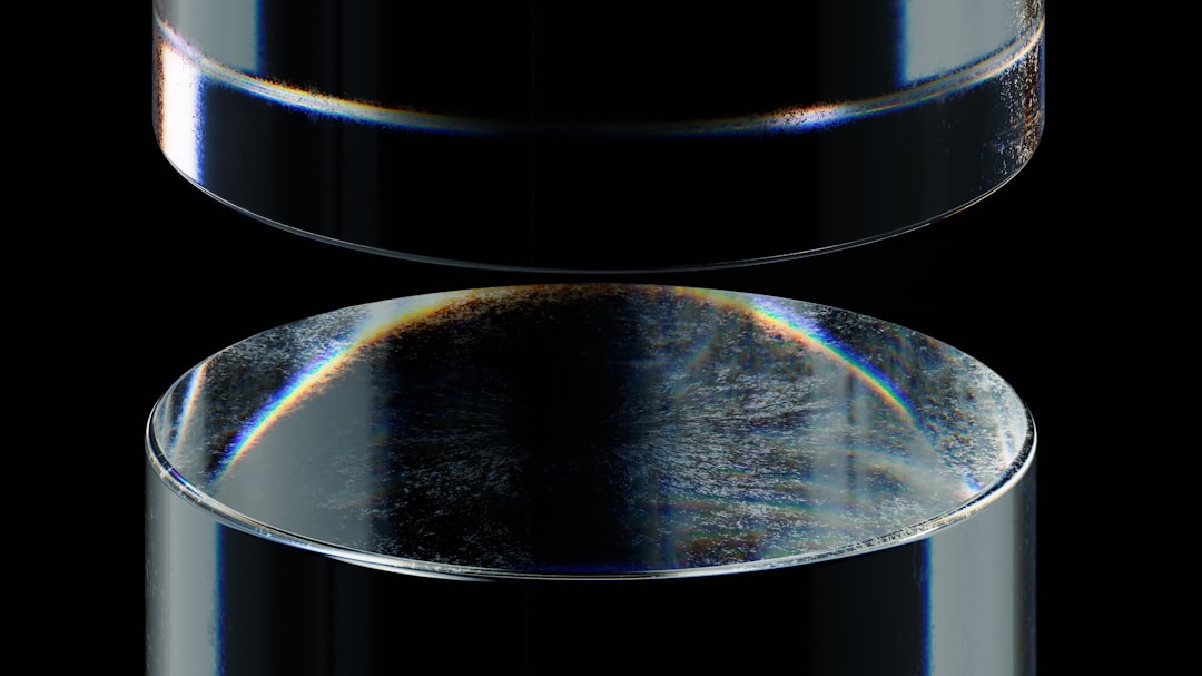 A close-up shot of a squeegee pushing UV ink across a screen onto a rotating bottle