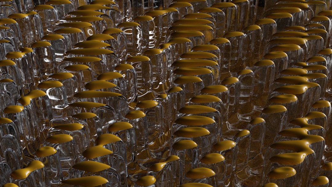 A row of plastic bottles moving on a conveyor under a UV curing lamp after being printed