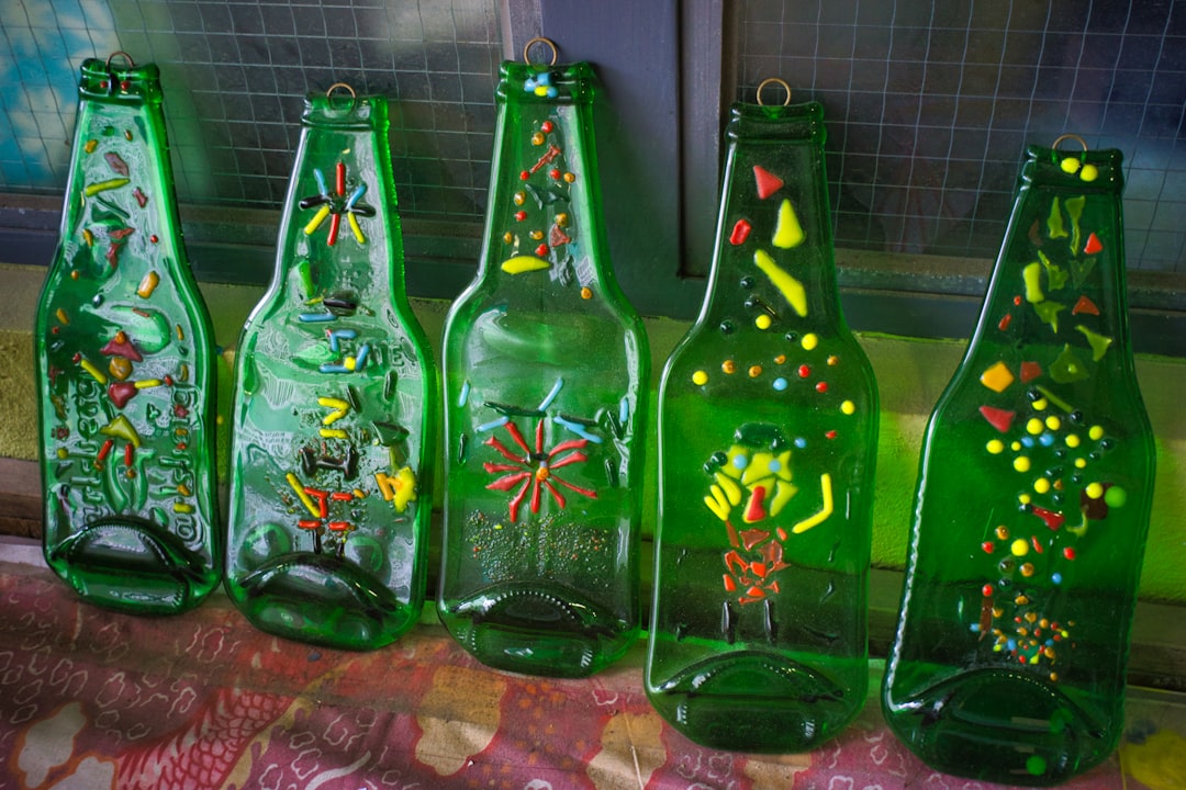 A collection of beautifully screen-printed glass bottles for various products like spirits, oils, and cosmetics