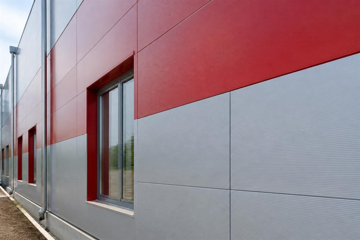 Original architectural illustration showing aligned blue PPGI wall cladding panels and consistent panel joints