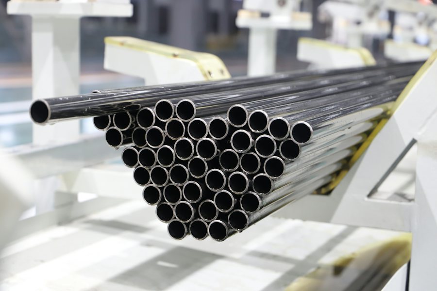 Finished steel pipes moving through industrial production handling equipment