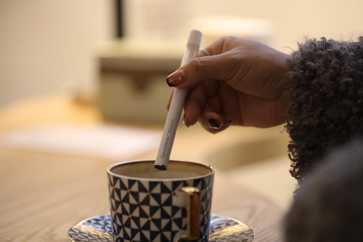 Person using a cannabis vape pen in a relaxed lifestyle setting