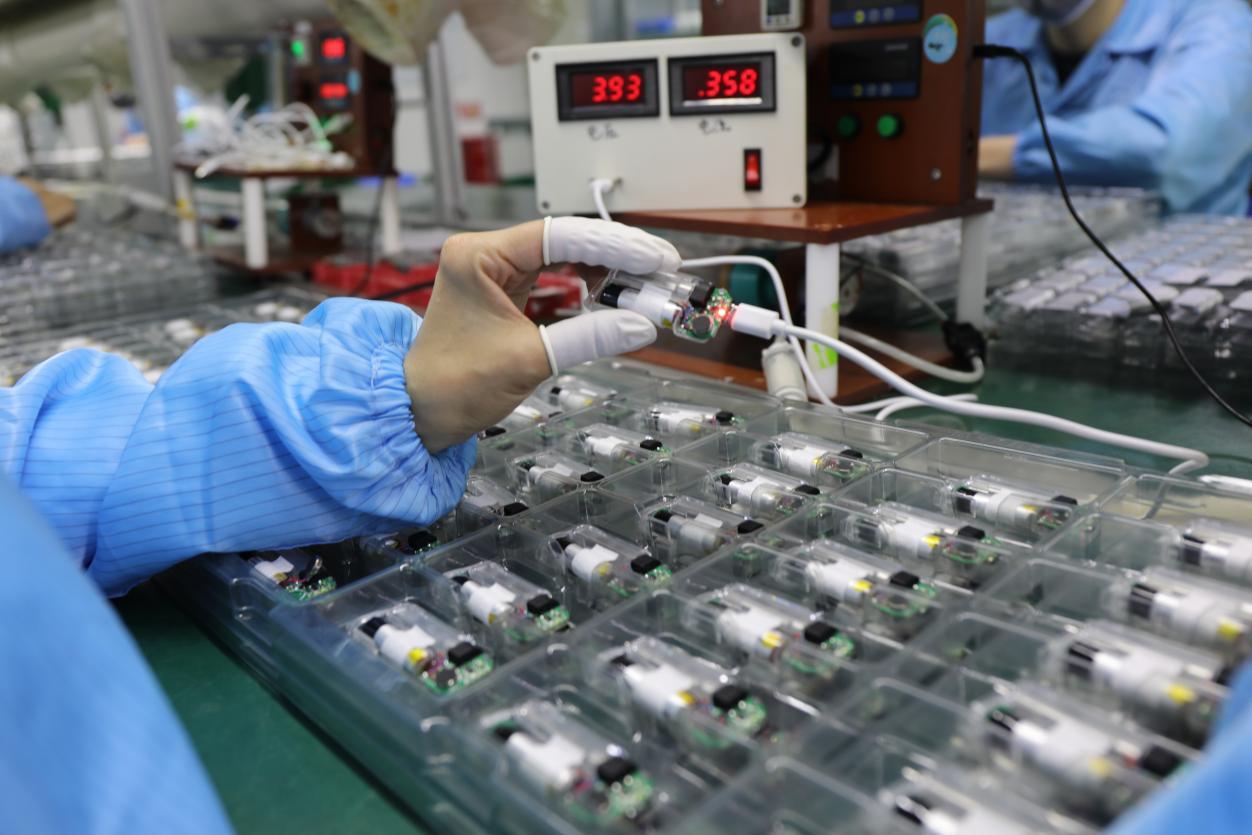 Quality control technician testing vape batteries on production line