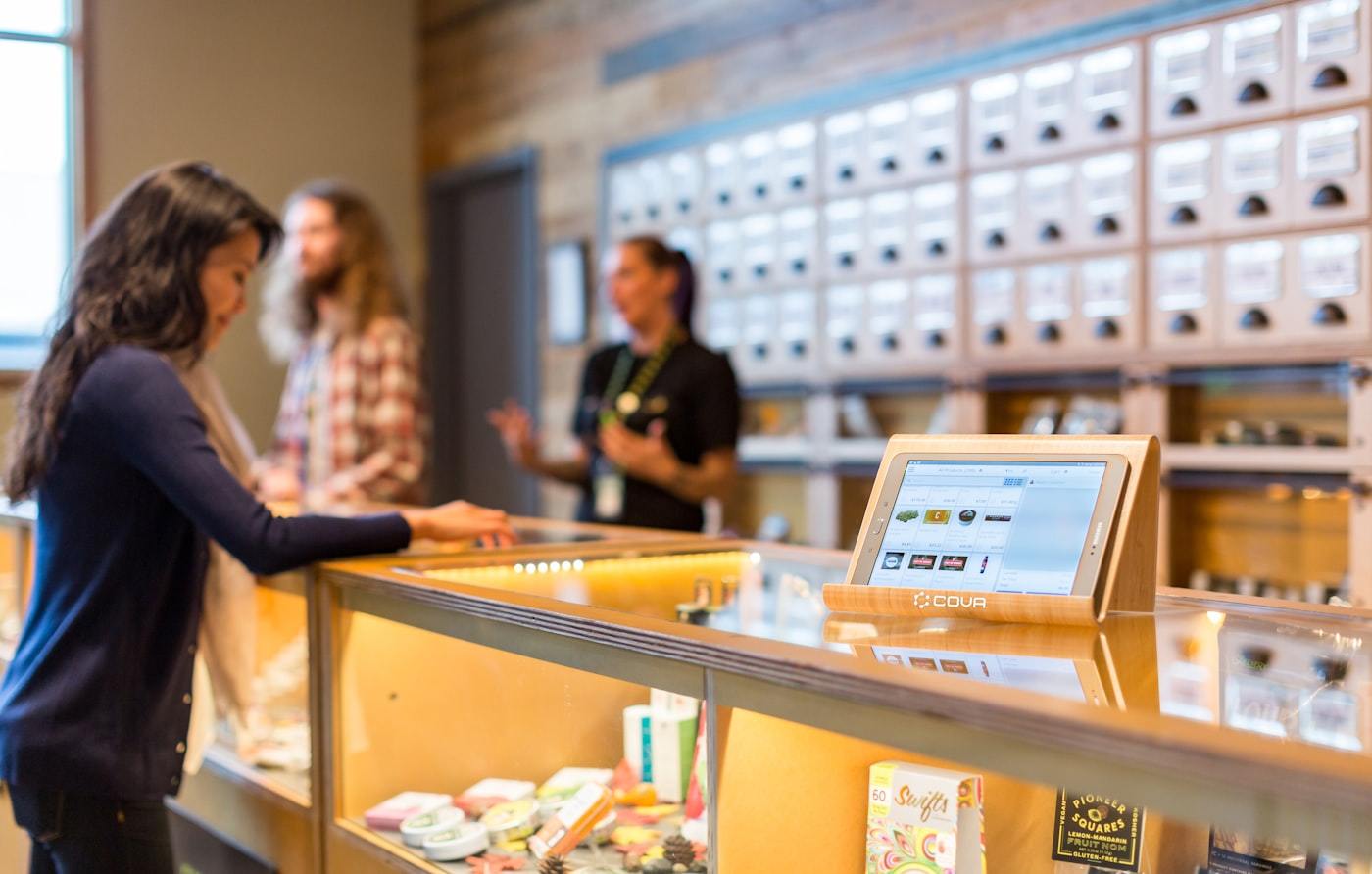 Modern cannabis vape dispensary where consumers choose cartridges and vape hardware