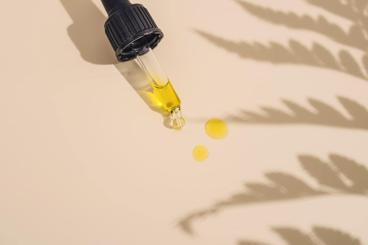Golden cannabis oil in a glass dropper bottle on a work table