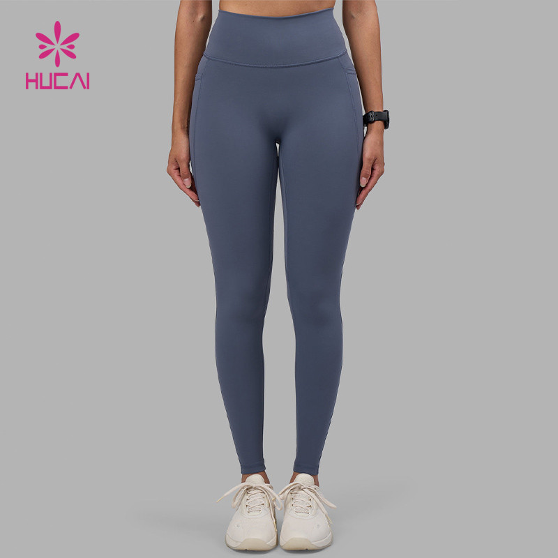 High-waist full-length women's training leggings in steel blue shown in a front fit view, illustrating waistband depth and leg line