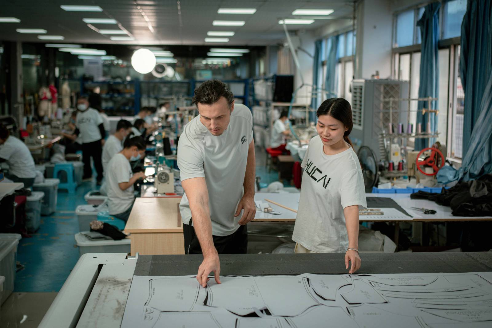 Pattern cutting table with paper pattern pieces being reviewed in a development room