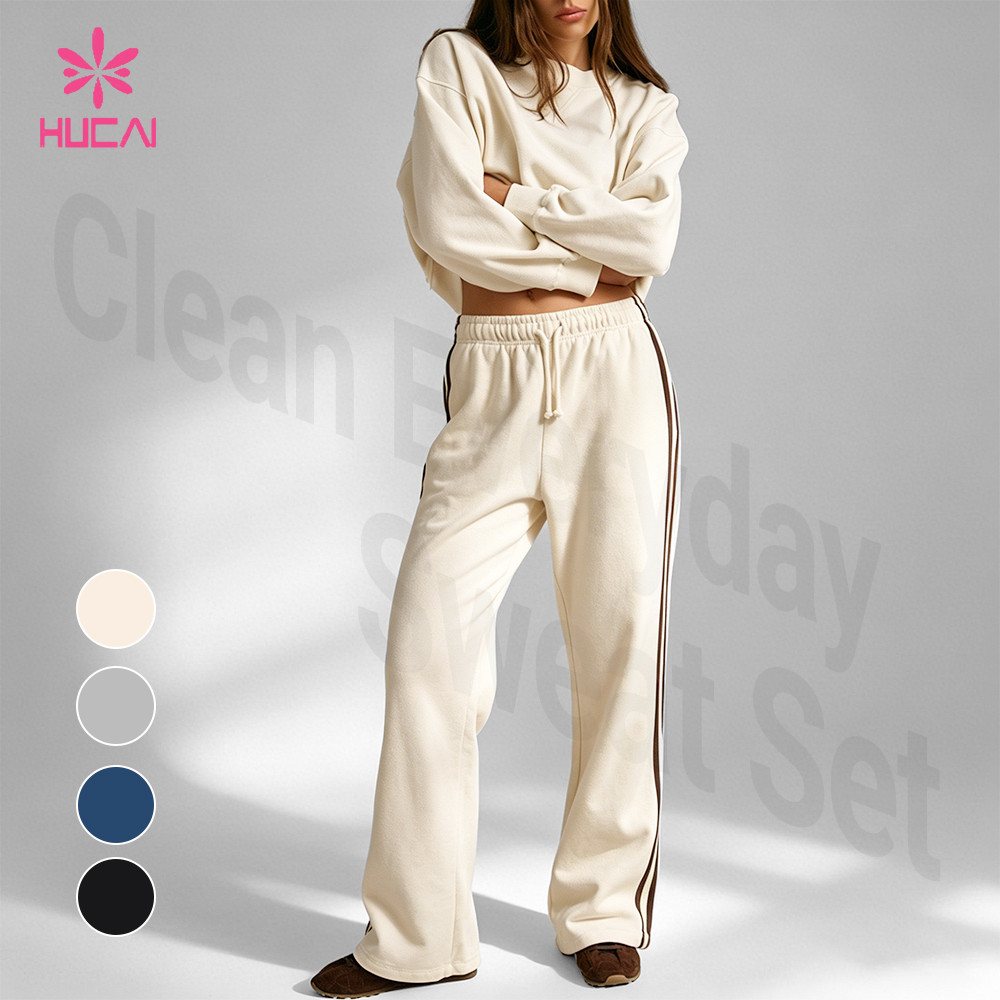 Cream sweatshirt and straight-leg sweatpants set with a contrast side stripe running down the leg of the bottom piece