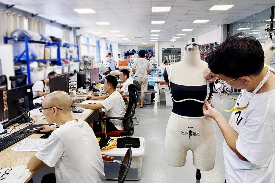 HUCAI women's pattern room: fitting a sample on a dress form with measuring tape