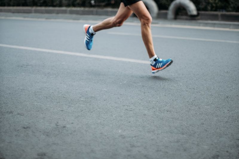 Male athlete running outdoors wearing layered quarter-zip training top