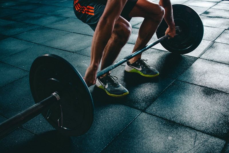 Man in athletic quarter-zip training top at gym performing warm-up exercises