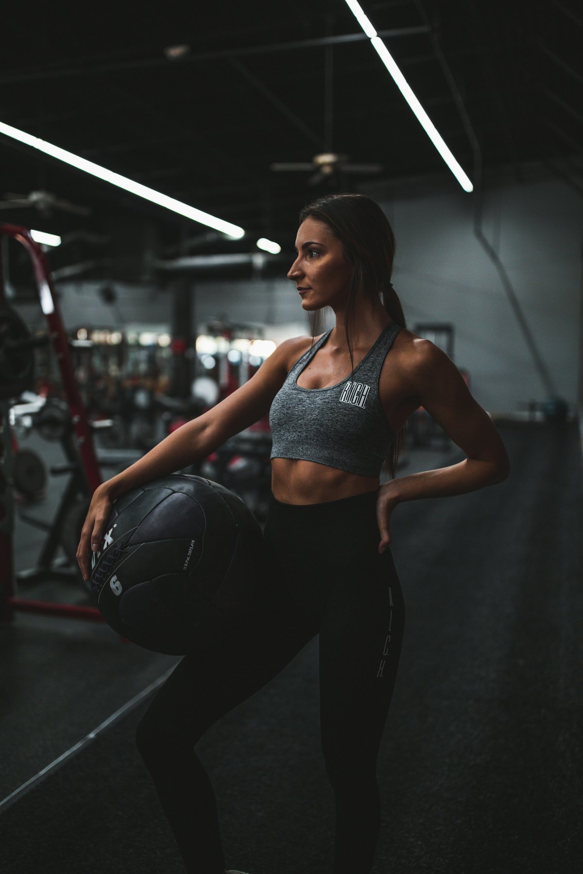 woman in athletic wear training with a stability ball in a studio