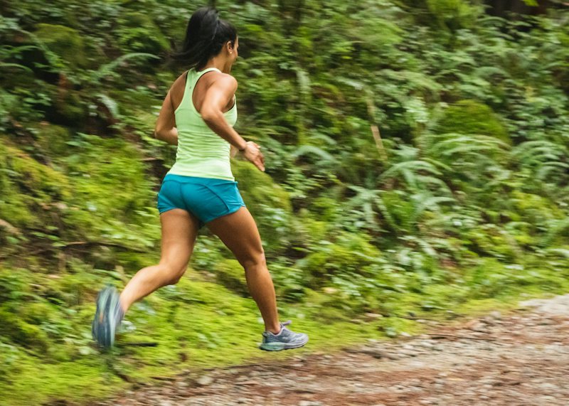 woman in a tank top running on a dirt road wearing lightweight running shorts
