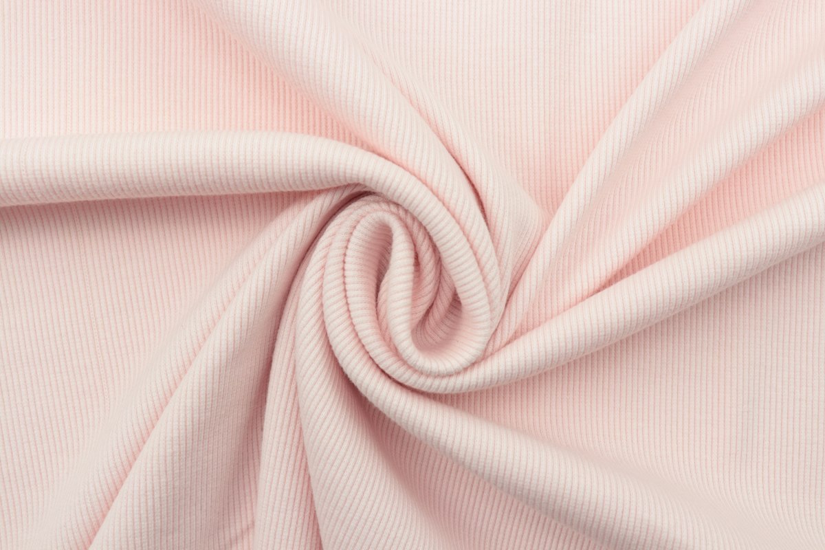 Close-up of pale pink rib knit fabric showing surface texture and recovery direction
