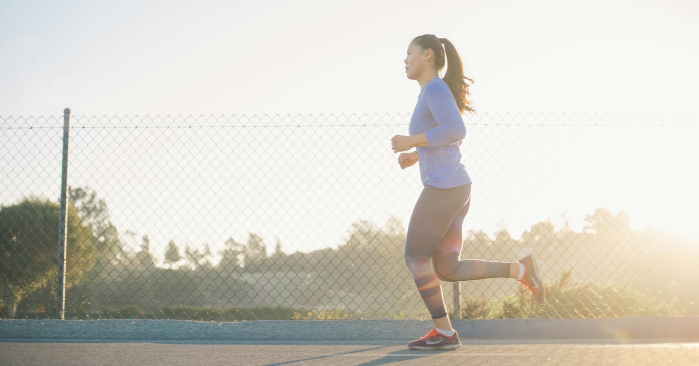 Runner wearing a black long-sleeve running top on an outdoor road in cool conditions