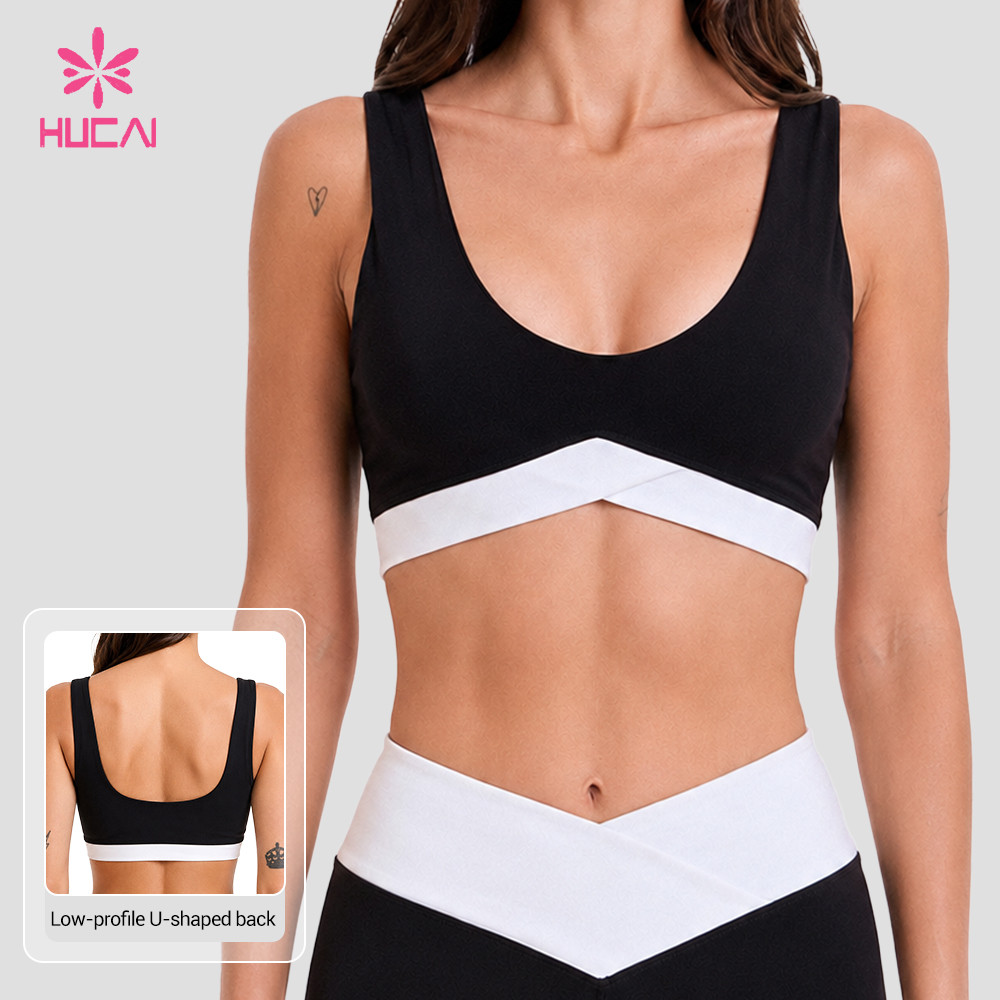 Custom black sports bra front view showing the white cross underbust band and scoop neckline