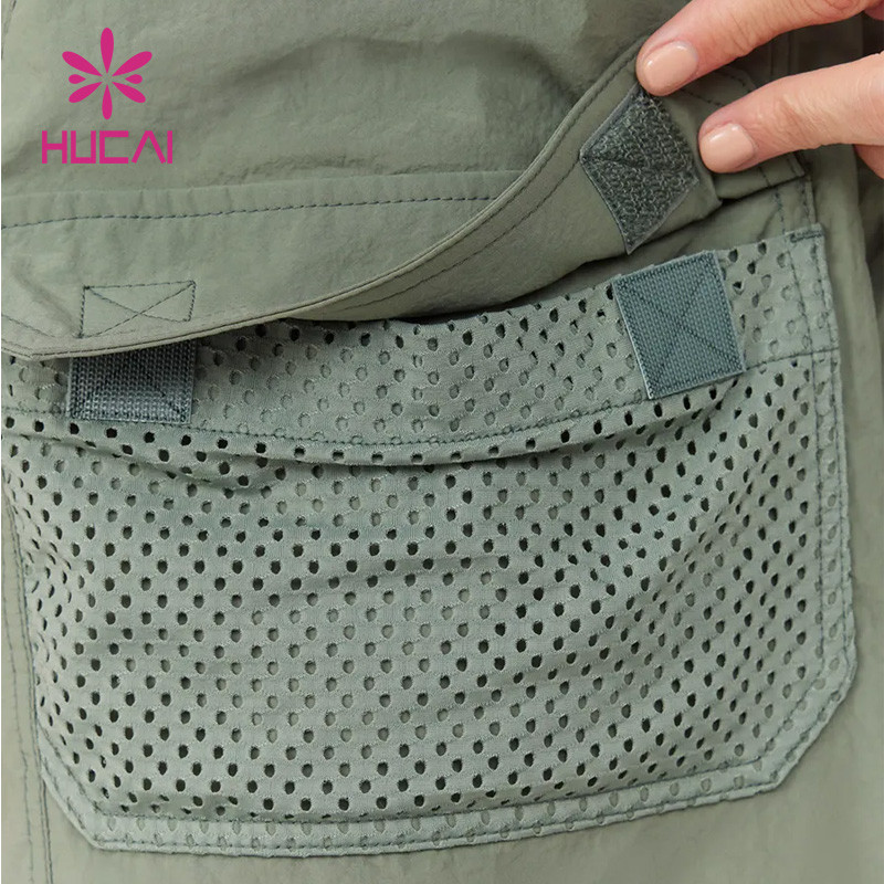 Close-up of a woven short's mesh pocket construction with reinforced stitching and hook-and-loop closure