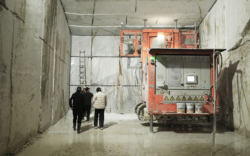 Wire-saw machine cutting a Tasso White marble block at the underground quarry face