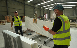Worker operating a bridge saw inside the VANJ factory