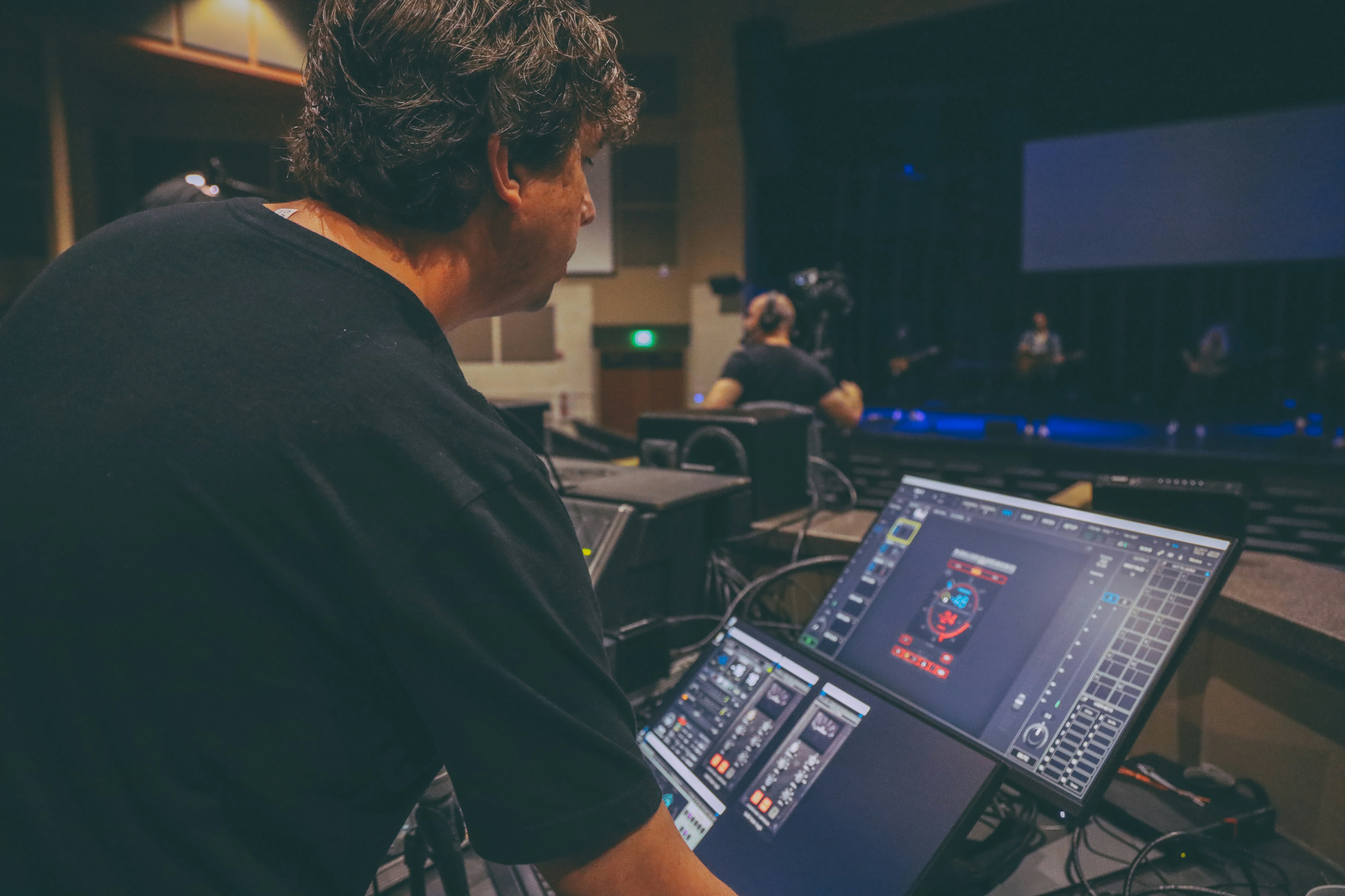 A sound engineer at a large digital mixing console during a concert