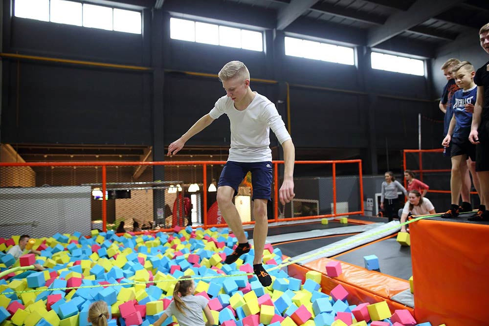 Trampoline with ball outlet pit