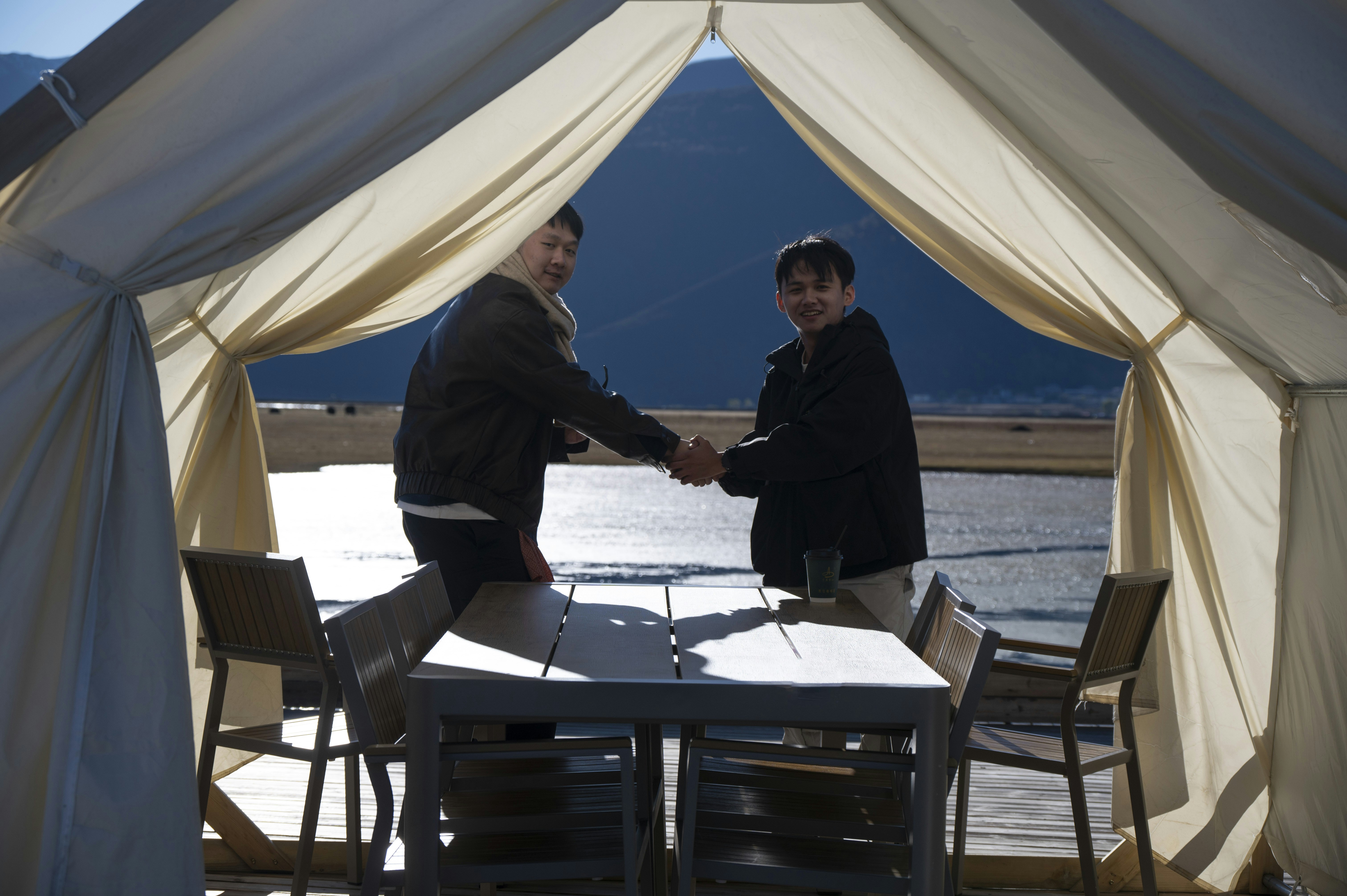 Two business professionals shaking hands at a negotiation table