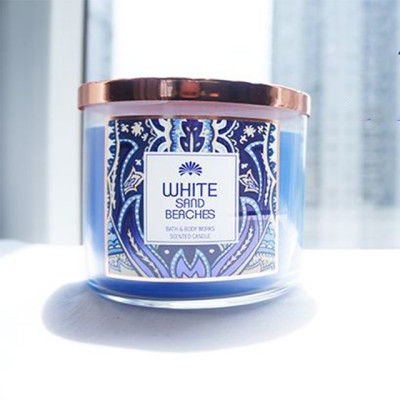 Natural three wick scented soy custom candles placed in colorful glass jars