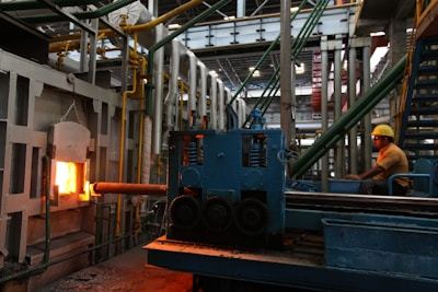 Industrial worker operating machinery in steel factory