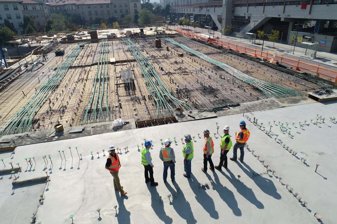 Workers on a large construction site with structural steel