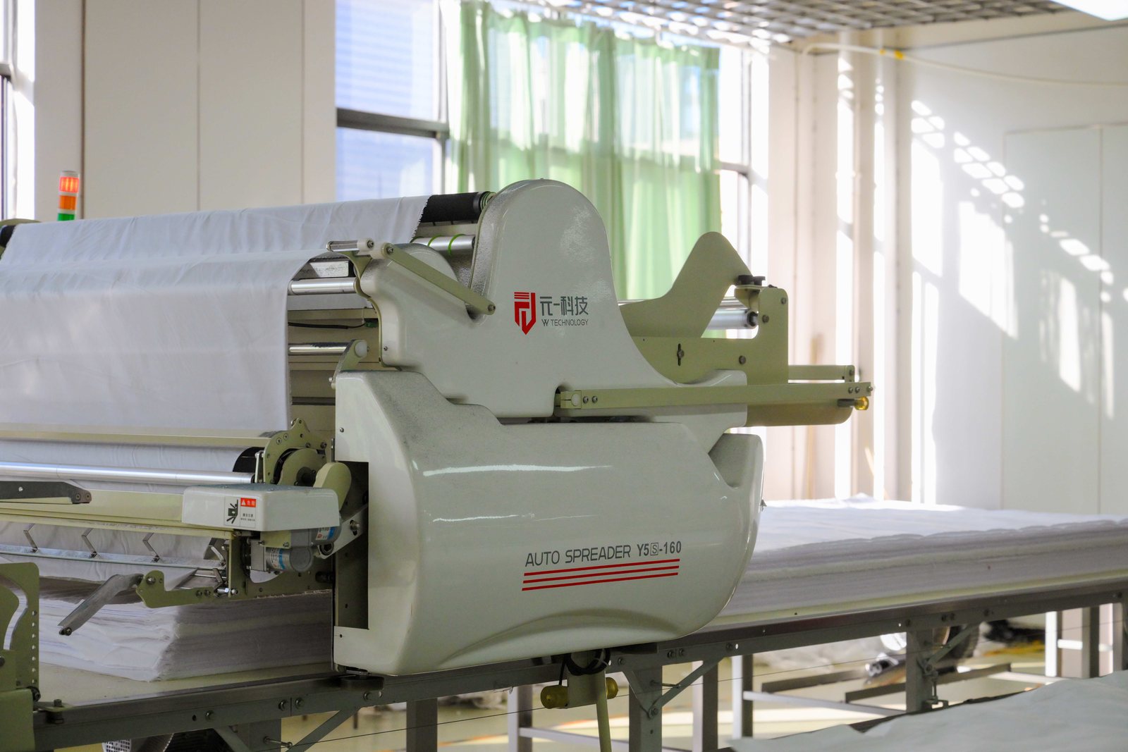 Spreading machine laying multiple plies of fabric for cutting