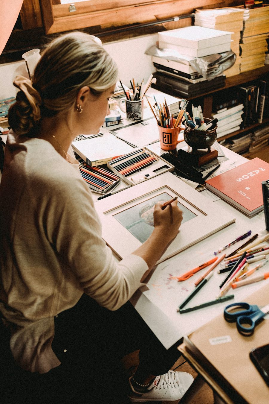 Artist using colored pencils at a creative workspace