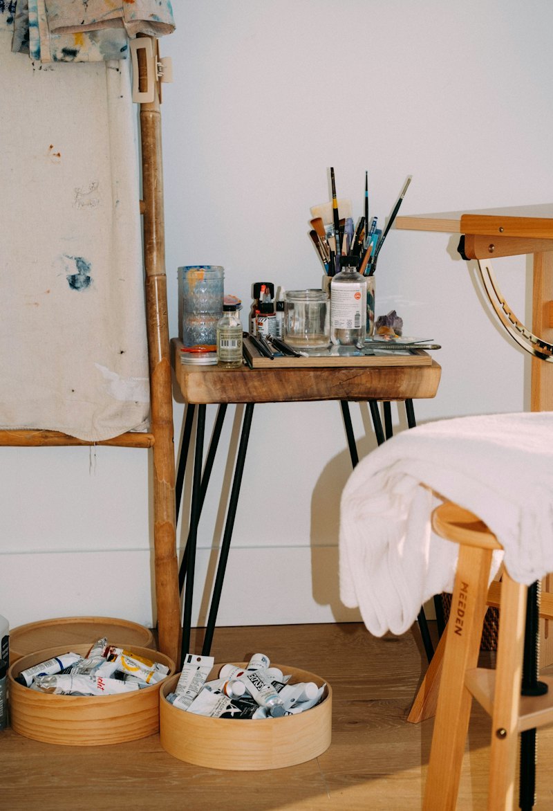 Artist studio with easel, paint jars and brush pots