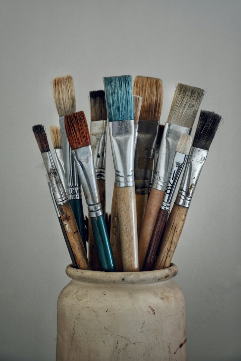 Mixed nylon and bristle paint brushes in a studio pot